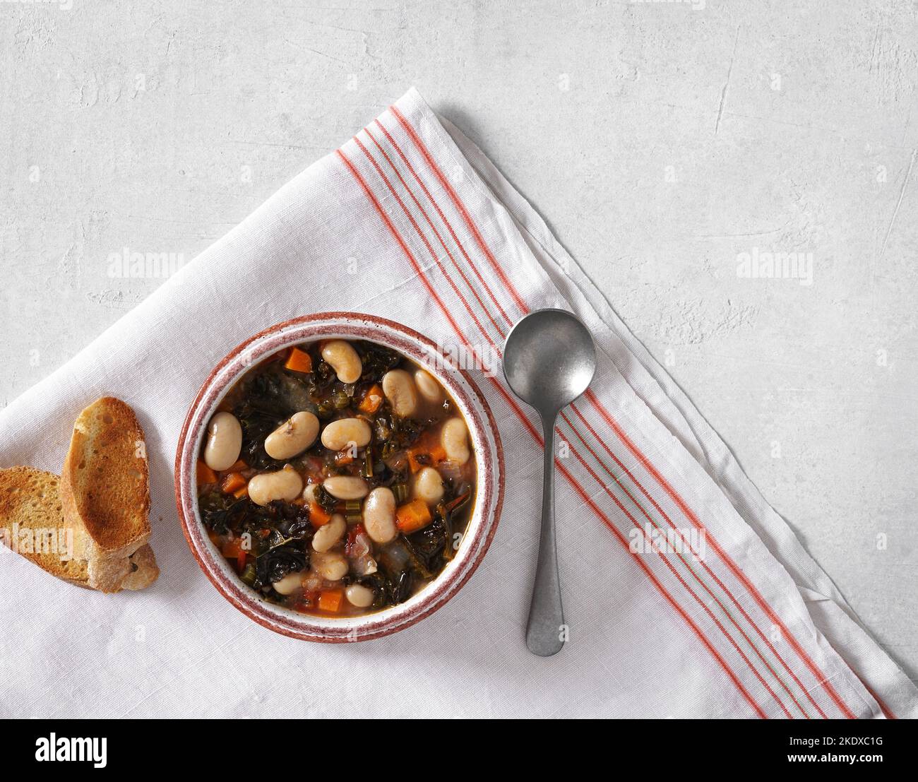 Wintersuppe mit verschiedenen Gemüse, Bohnen, Grünkohl. Typisch toskanische Suppe, Ribollita. Italienisches Komfortessen. Draufsicht, Kopierraum Stockfoto