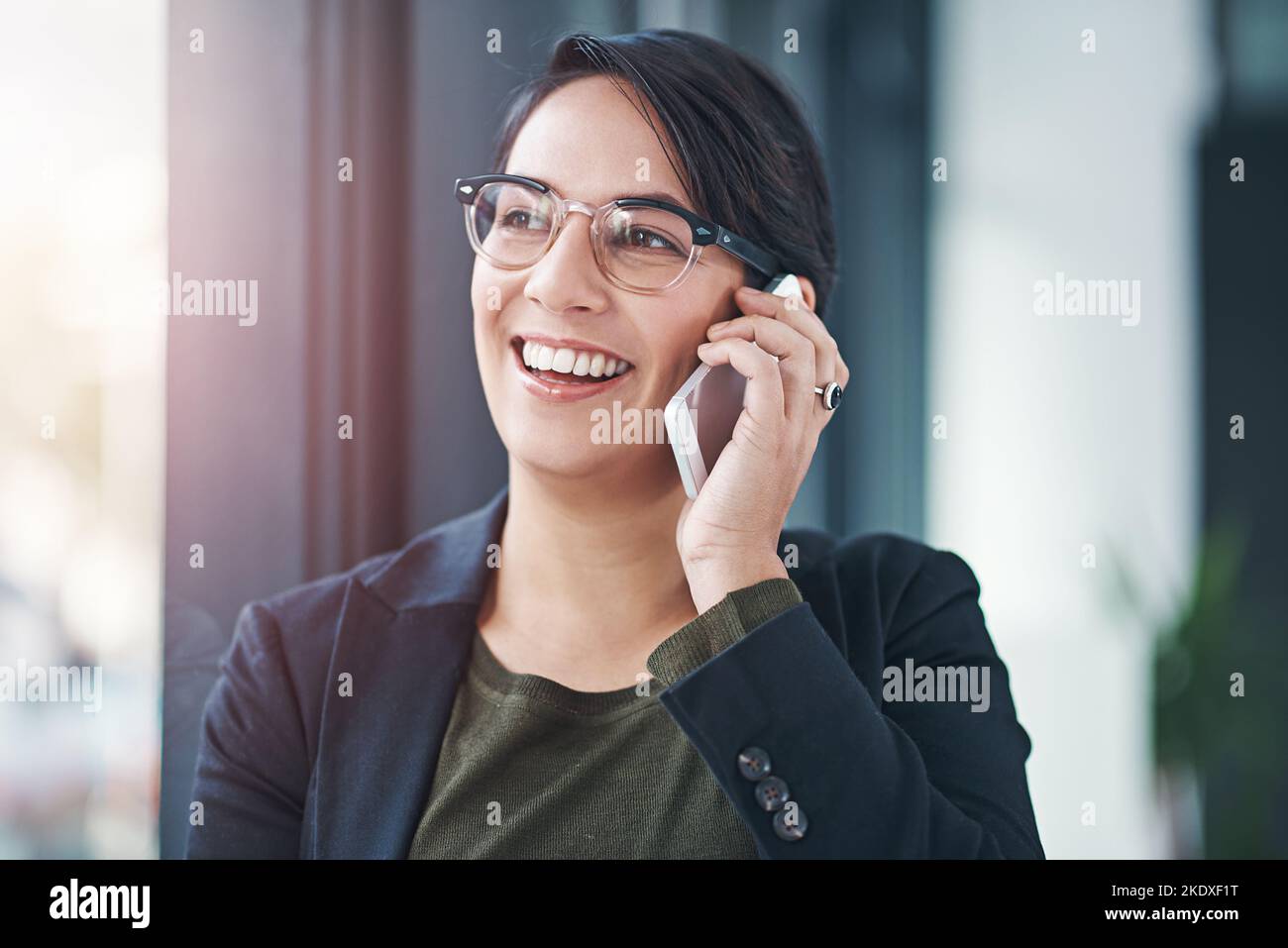 Klingt gut. Eine erfolgreiche Geschäftsfrau benutzt ihr Handy im Büro. Stockfoto