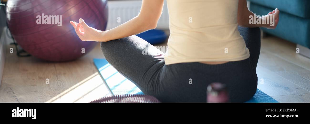 Frau praktiziert Yoga zu Hause, Atemkontrolle und Meditation Stockfoto