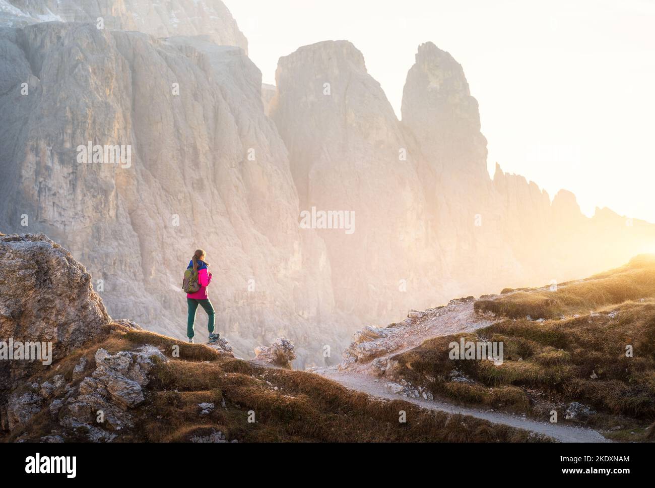 Junge Frau mit Rucksack auf dem Bergweg und Berg Stockfoto