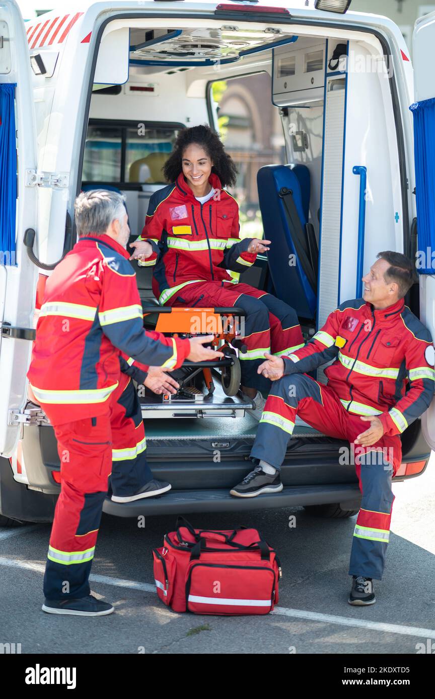 EMS-Mitarbeiter in roten Uniformen waren an einem Gespräch beteiligt Stockfoto