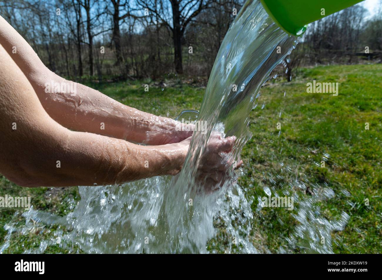 Händewaschen durch Ausgießen von Wasser im Freien. Stockfoto