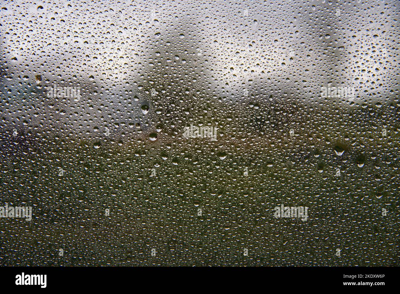 Wassertropfen auf Fenster und ländliche Landschaft. Stockfoto