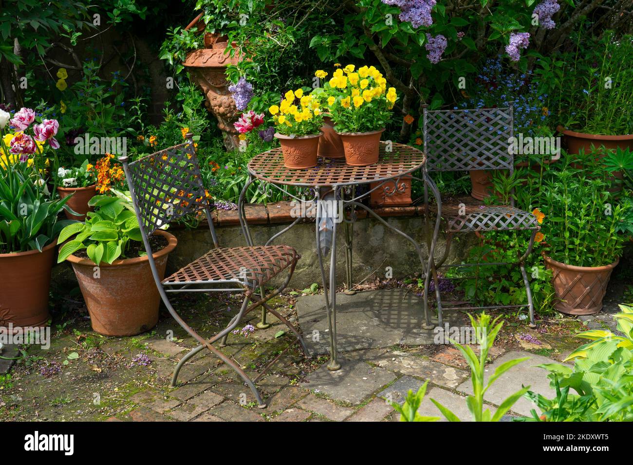 Metallstühle und -Tisch im Garten von Whichford Pottery , Whichford, Cotswolds, England Stockfoto