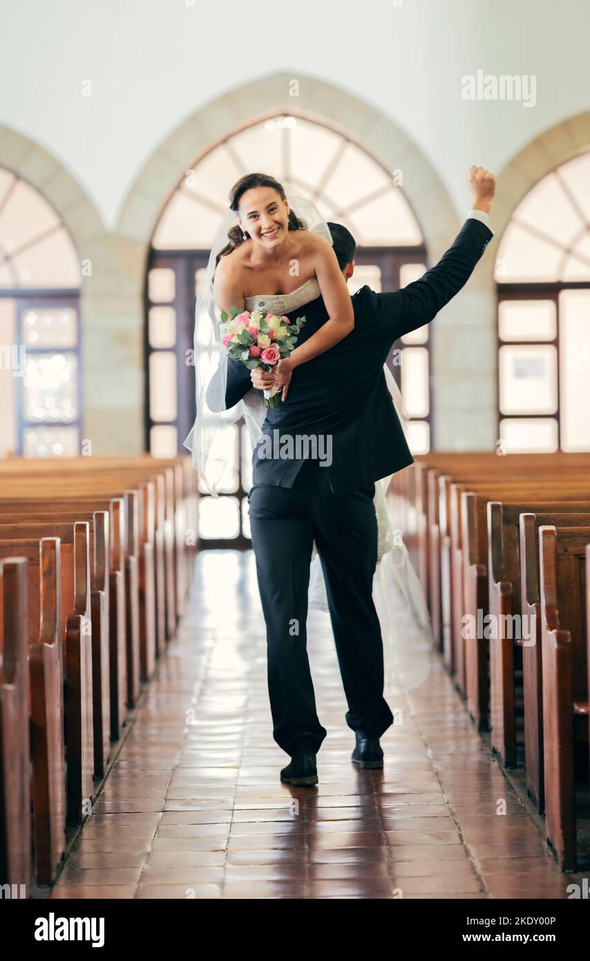 Feier, Tragen und Mann mit Braut nach der Hochzeit in einer Kirche, glücklich und lächeln für Hochzeit Ereignis. Liebe, Comic und Paar, die in einem Gebäude spazieren gehen Stockfoto