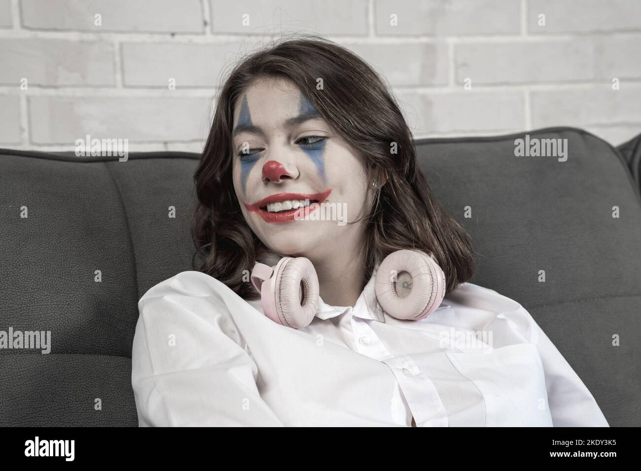 Ein Teenager-Mädchen mit Clown Make-up spricht emotional über etwas Stockfoto