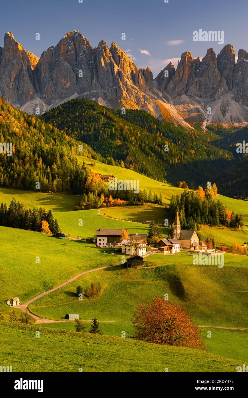 Ein vertikales Bild von einem herbstlichen Sonnenuntergang an der berühmten Kirche und dem Dorf Santa Maddalena vor den Geisler- oder Geisler-Dolomiten Stockfoto