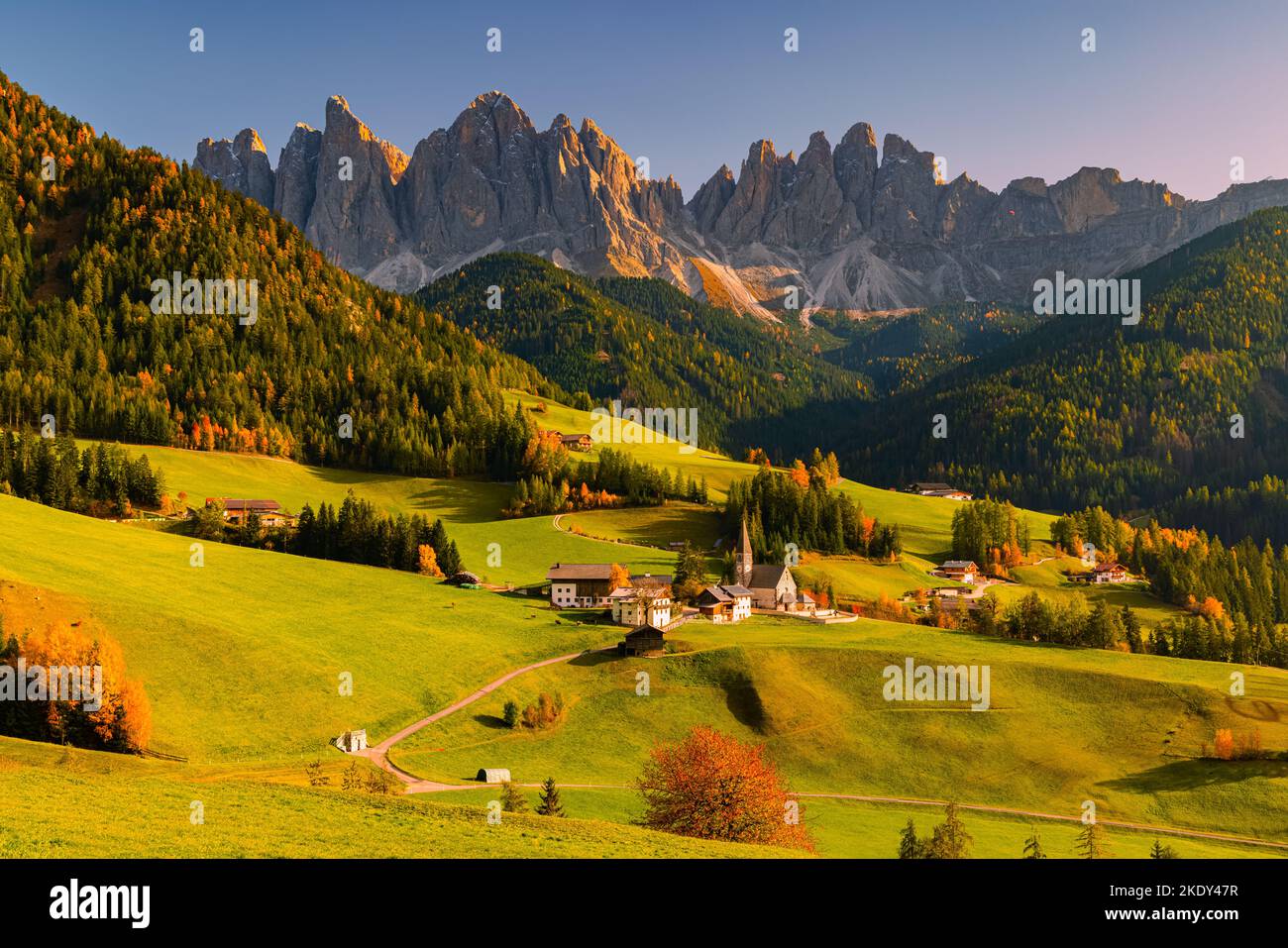 Ein Bild von einem herbstlichen Sonnenuntergang in der berühmten Kirche und dem Dorf Santa Maddalena vor den Geisler- oder Geisler-Dolomiten im Val di Stockfoto