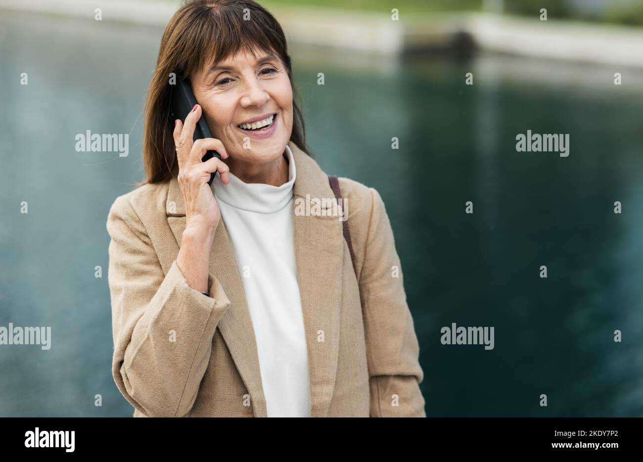 Glückliche, ältere Frau und Telefonanruf für Gespräche, Diskussionen und mit einem Lächeln im Freien. Ruhestand, reife Frau und selbstbewusste Dame mit Smartphone Stockfoto