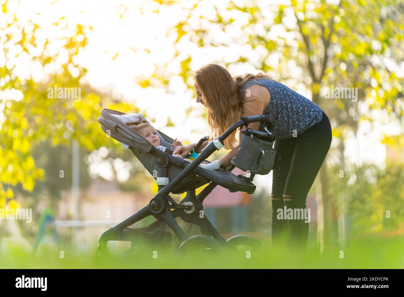 Mutter kümmert sich im Park um ihren Sohn Stockfoto
