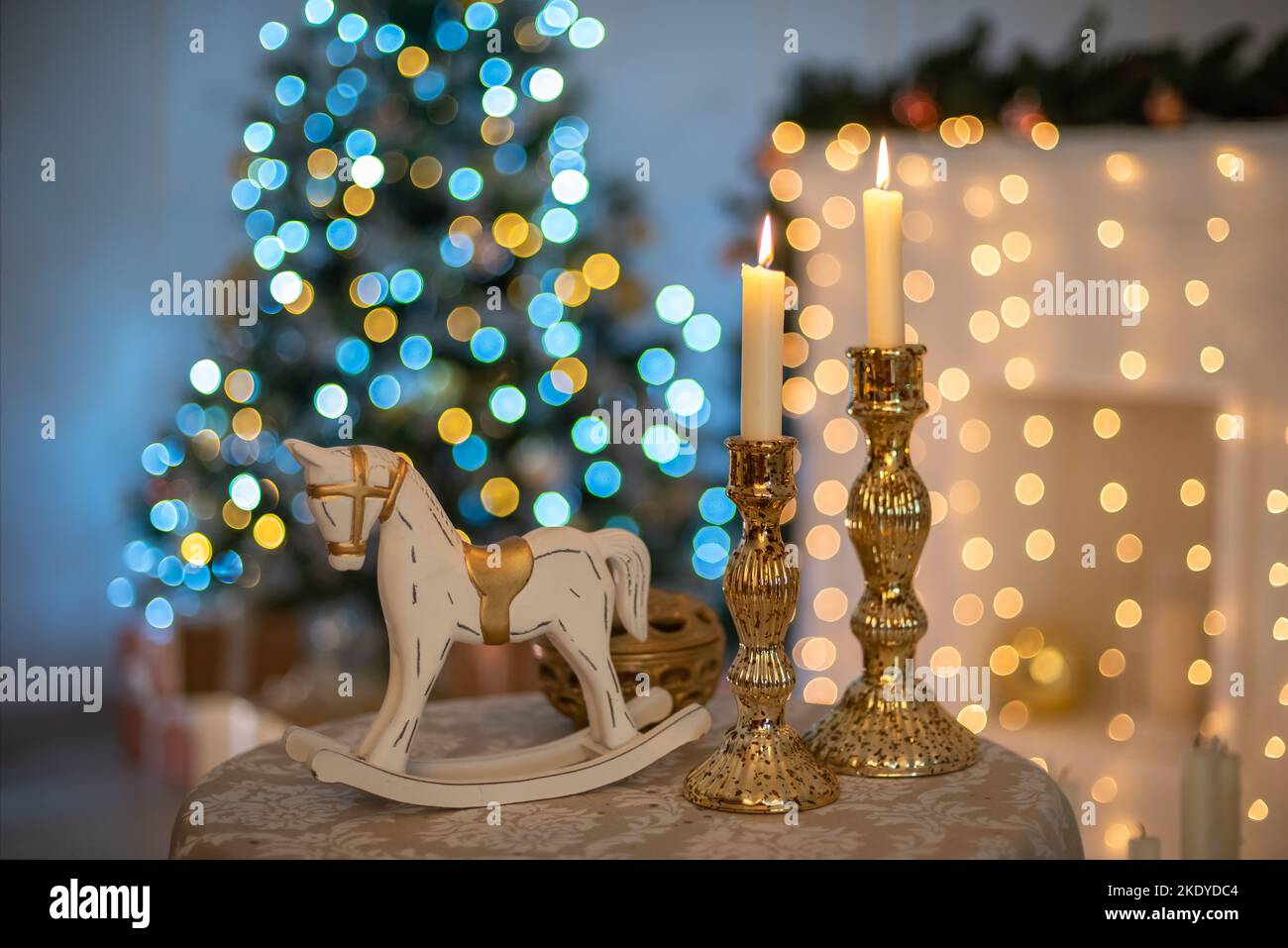 Neujahrstisch mit Kerzen und einem Spielzeug-Pferd. Stockfoto