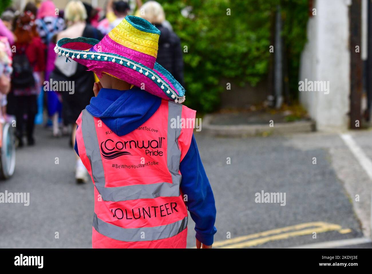 Ein junger ehrenamtlicher Steward bei der farbenfrohen Cornwall Prides Pride Parade im Zentrum von Newquay in Großbritannien. Stockfoto