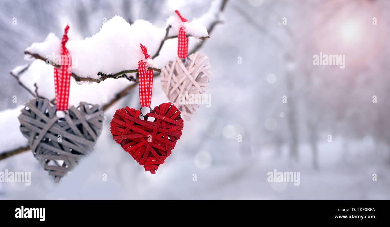 Roten Herzen auf verschneiter Baum im Winter. Urlaub. Happy Valentines Day Feier. Herz Liebe Konzept. Stockfoto