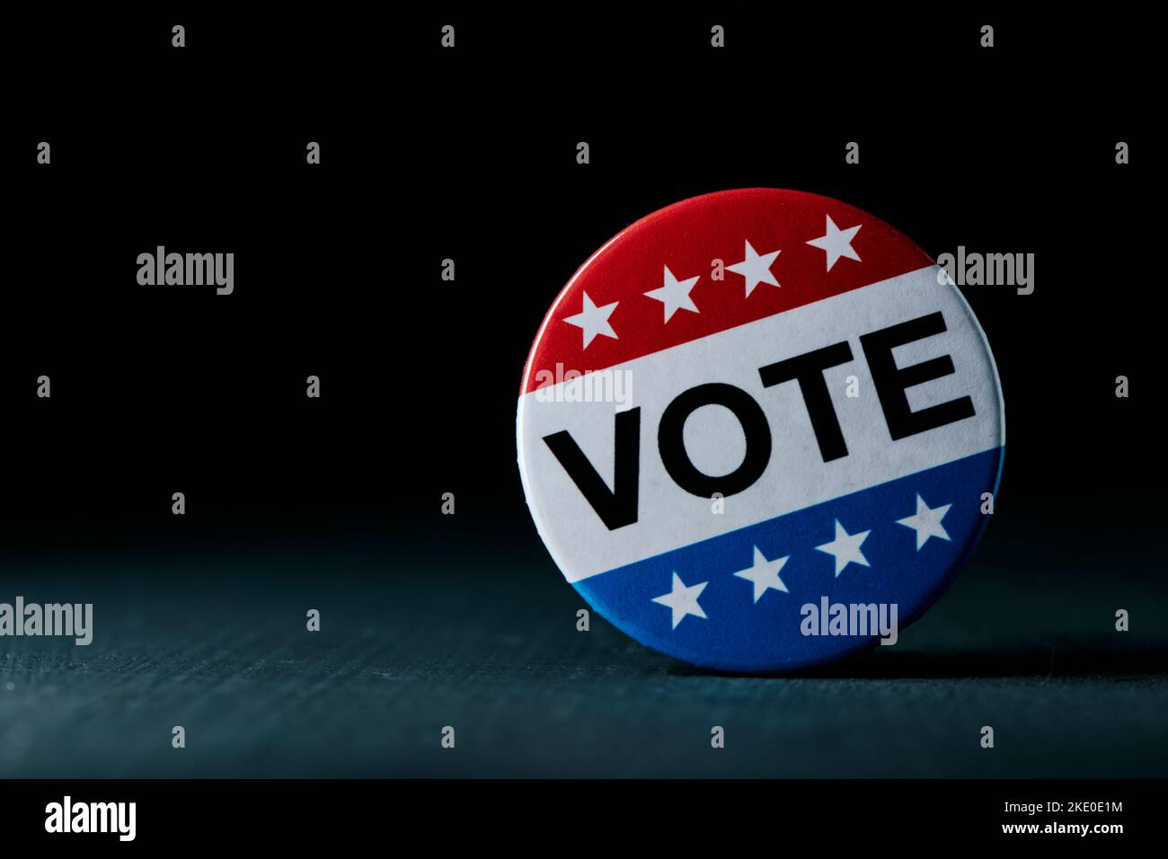 Nahaufnahme eines Stimmabzeichens für die Wahlen in den Vereinigten Staaten auf einer dunkelgrauen Oberfläche, mit einigen Leerzeichen auf der linken Seite Stockfoto