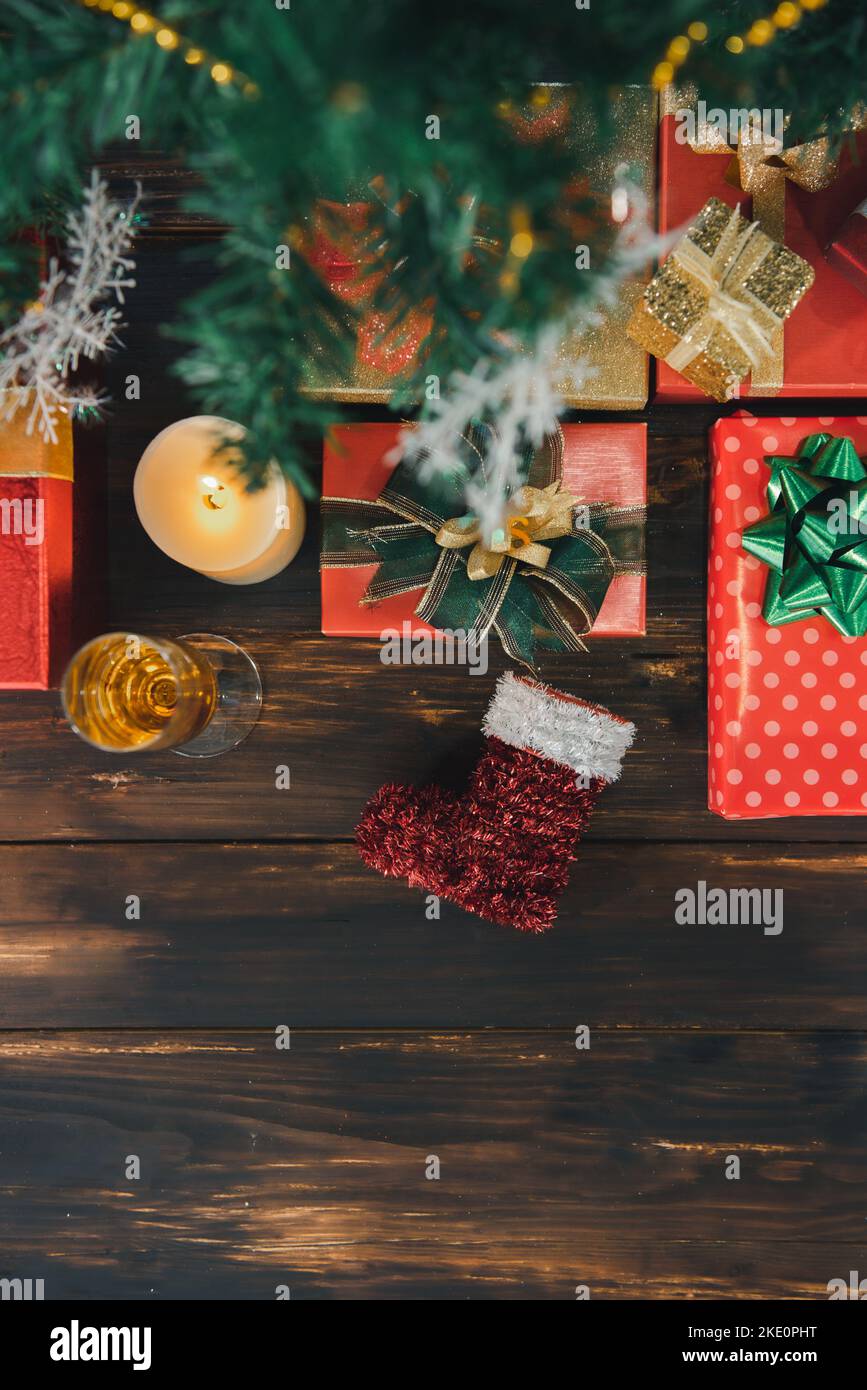 Weihnachtslichter und Dekoration auf dem Holzbrett mit Geschenken, die einen Rahmen mit Kopierraum bilden, Draufsicht. Stockfoto
