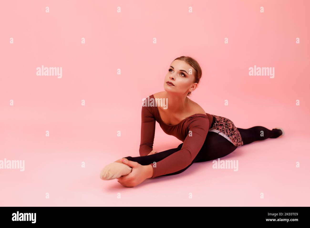 Ballerina sitzt im Kreuzspalt Stockfoto