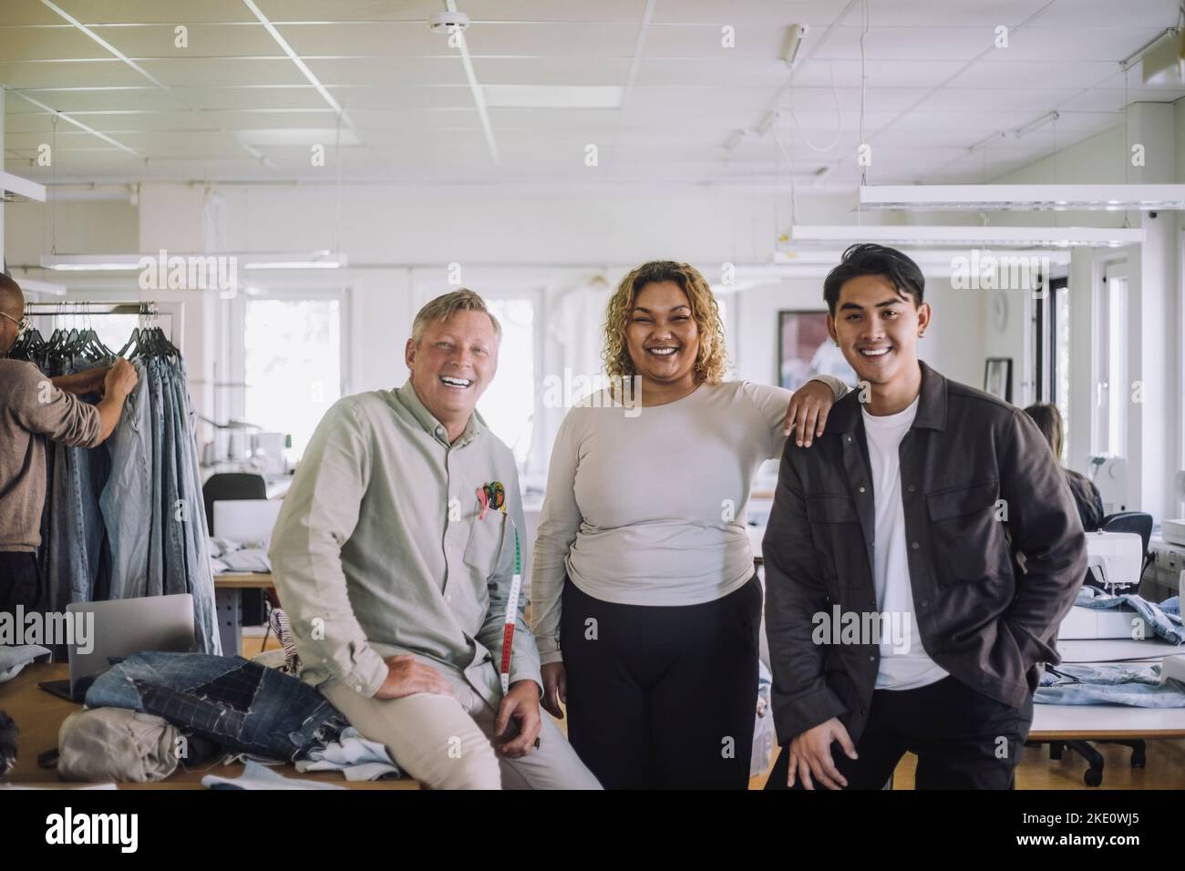 Junge Modedesignerin mit männlichen Kollegen im Workshop Stockfoto