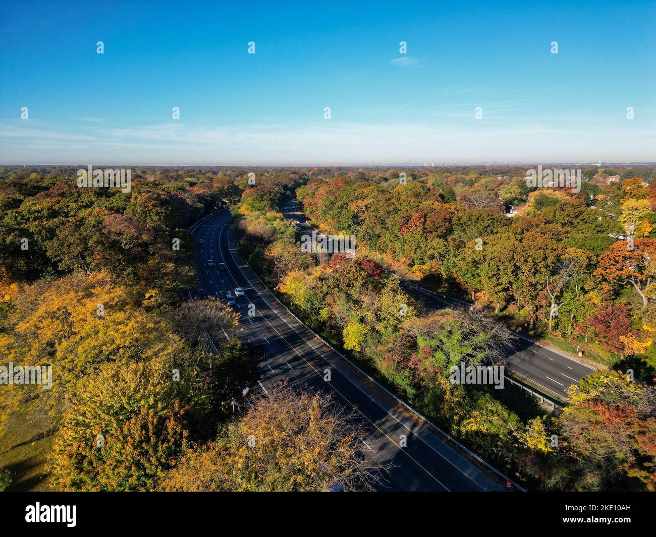 Eine Luftaufnahme der Herbstbäume entlang einer asphaltierten Straße an einem sonnigen Tag auf Long Island, NY Stockfoto
