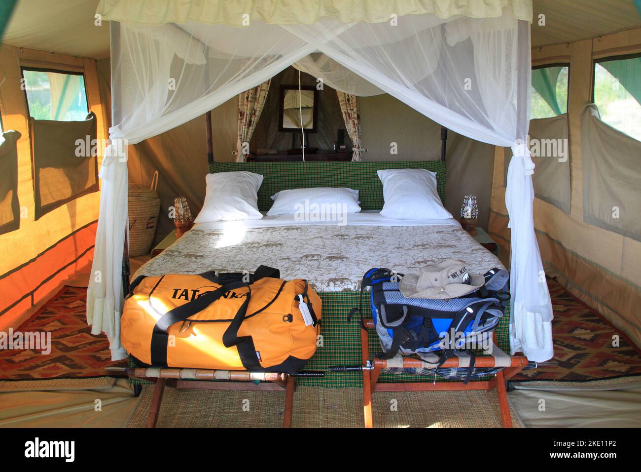 Großes, komfortables Doppelbett mit Baldachin in einer Safarizelt-Lodge im Tarangire National Park in Tansania Afrika. Stockfoto