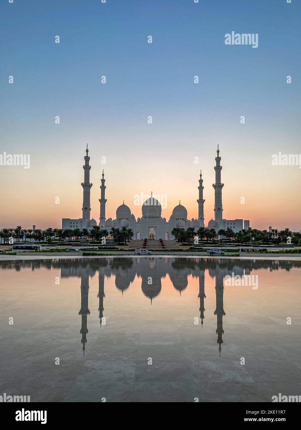 Die große Moschee des Scheich Zayed in Abu Dhabi bei Sonnenuntergang vom reflektierenden Pool des Wahat Al Karama-Kriegsdenkmals aus gesehen Stockfoto