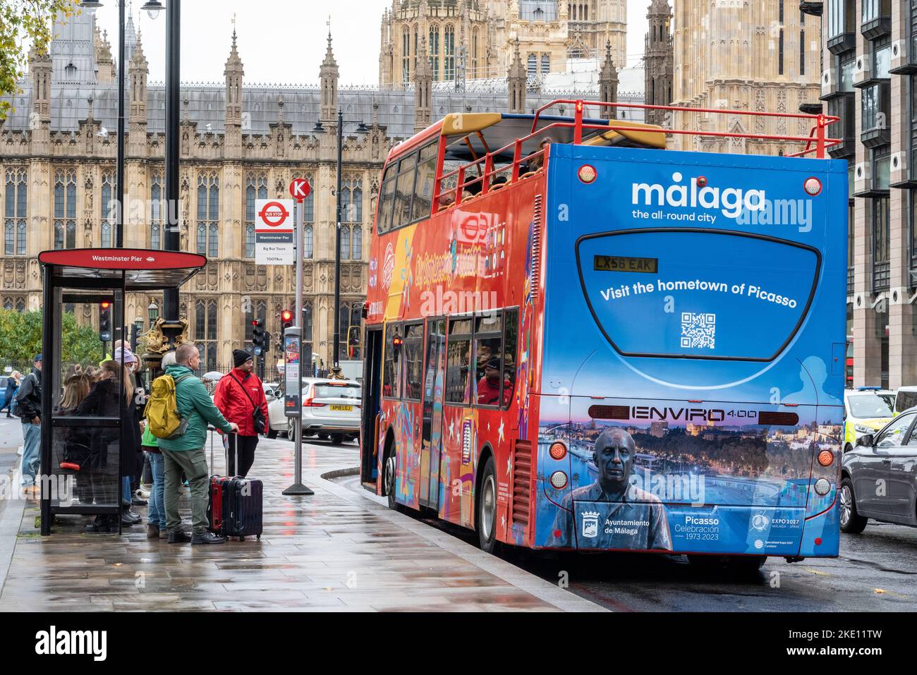 Tourbus in London, Großbritannien, an einem nassen, düsteren, regnerischen Tag, Werbung Malaga, Spanien, die Allround-Stadt. Besuchen Sie die Heimatstadt von Picasso. Kontrastierendes Wetter Stockfoto
