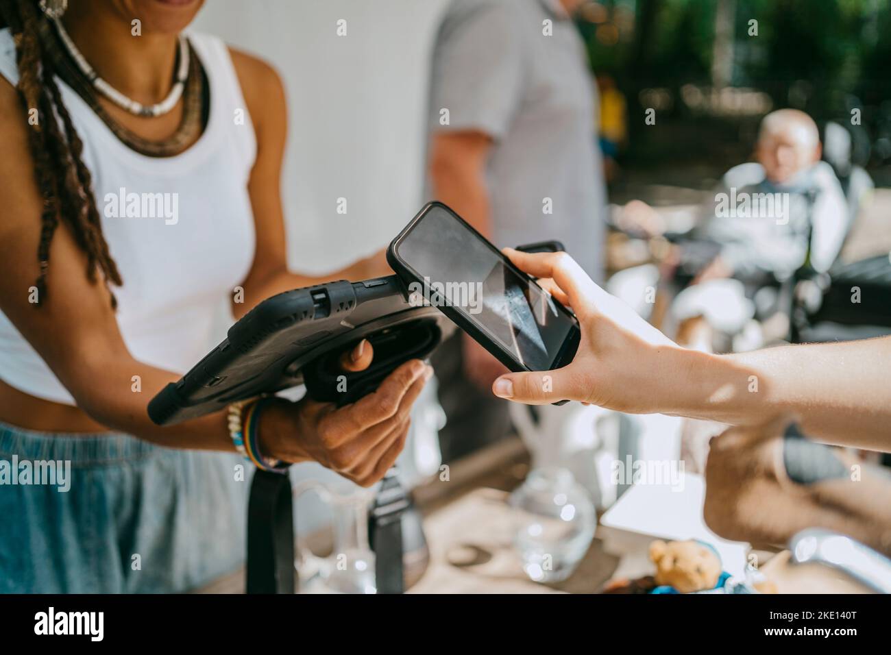 Hand einer Frau, die kontaktlos bezahlt, während sie auf dem Flohmarkt einkaufen Stockfoto