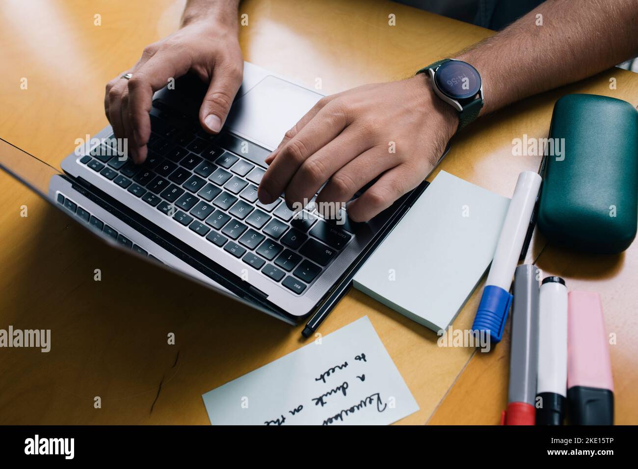 Zugeschnittenes Bild des Computerprogrammierers, der auf dem Laptop am Schreibtisch in der Startup-Firma tippt Stockfoto