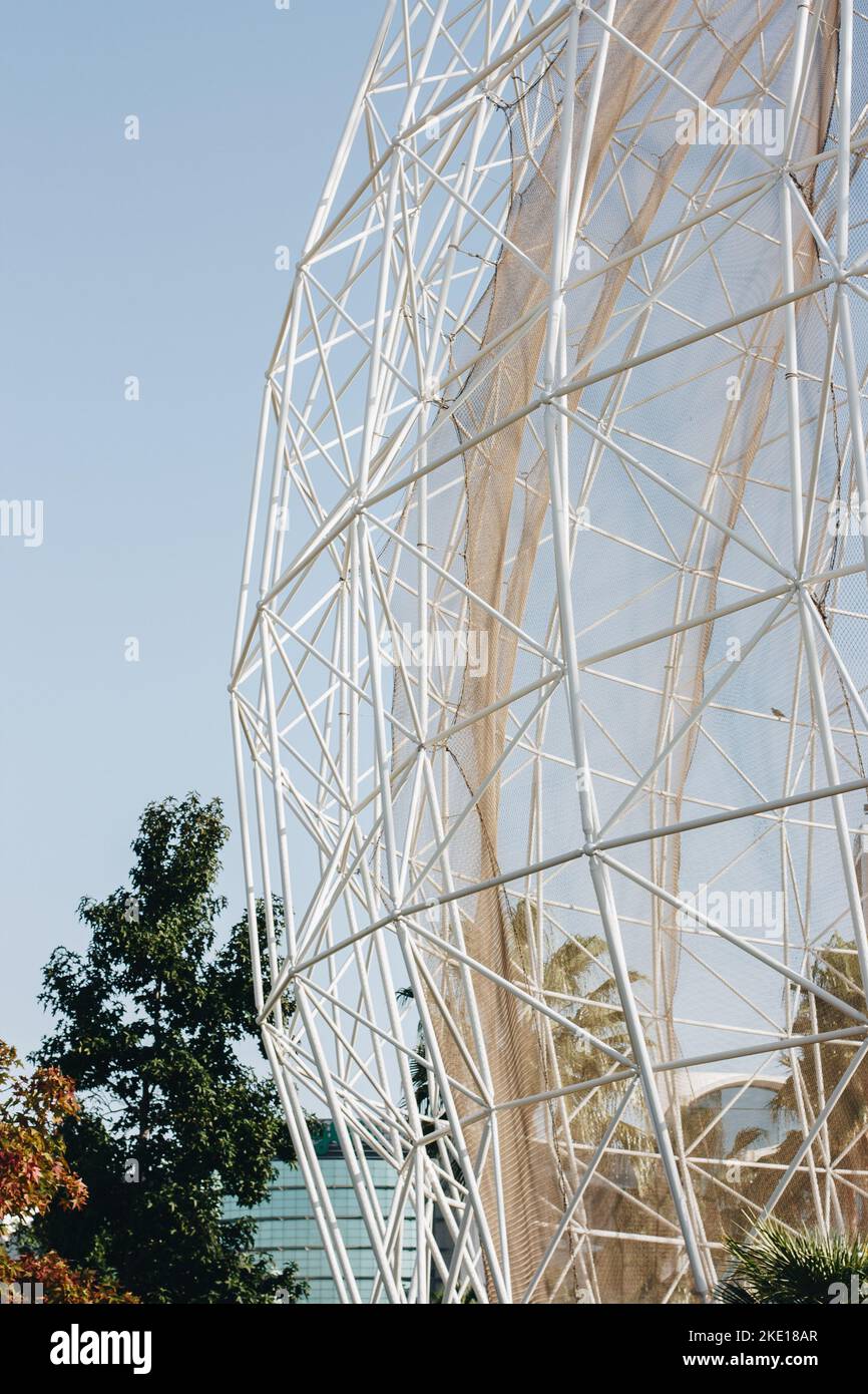 Riesiger Käfig aus weißem Metall in einem Zoo für einen Vogel unter blauem Himmel Stockfoto