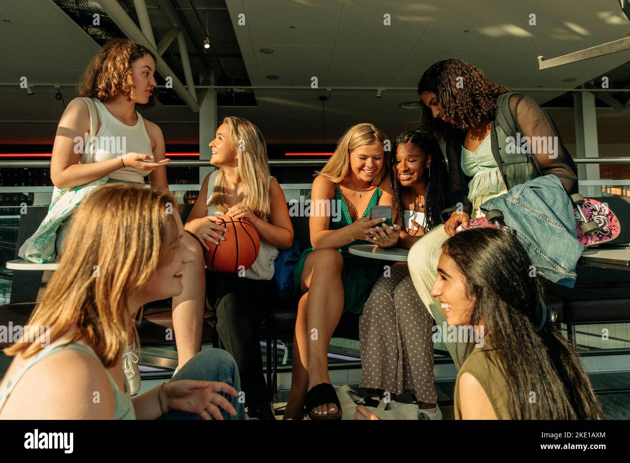 Teenager-Mädchen unterhalten sich während eines sonnigen Tages vor dem Einkaufszentrum Stockfoto