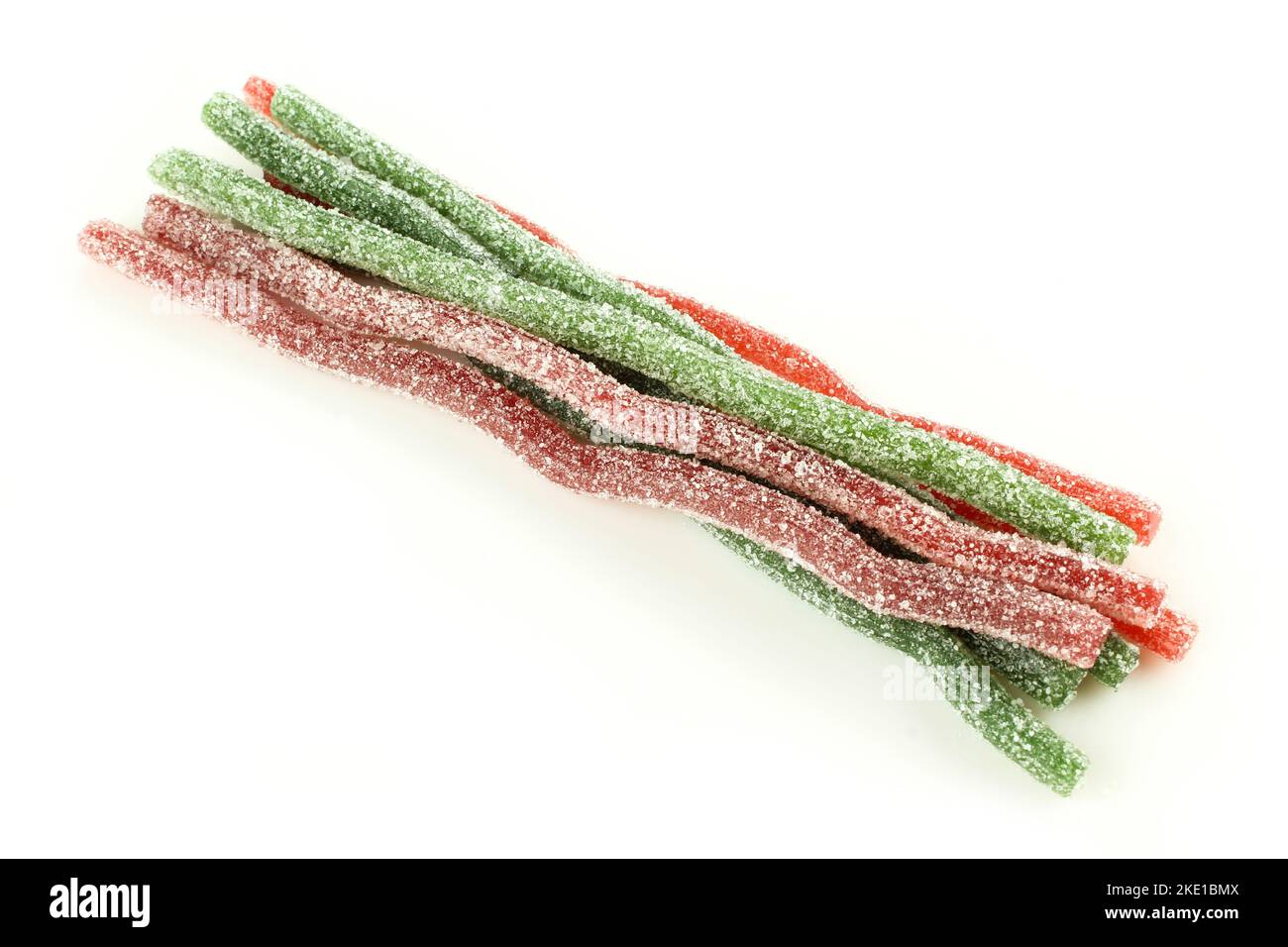 Gruppe von roten, grünen, kauen Würmern auf weißem Hintergrund isoliert. Zuckerbeschichtete saure Süßigkeiten für Kinder Stockfoto