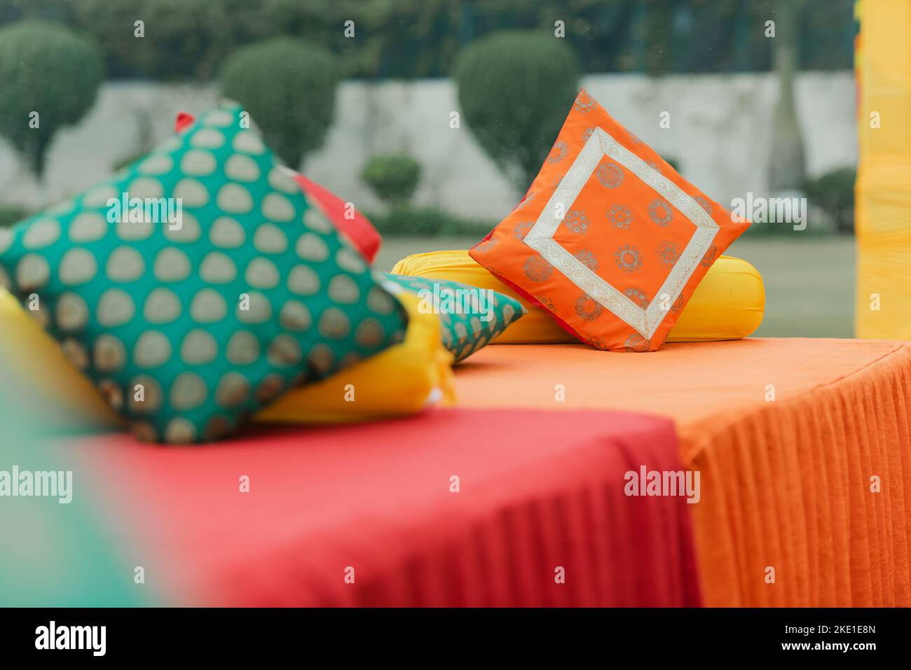 Farbenfrohe, elegante Hochzeitslocation mit Pastellfarben und elegantem Dekor im Freien mit Orchideenblumen und farbenfrohem Tischtuch für den Hochzeitsempfang in Indien. Stockfoto