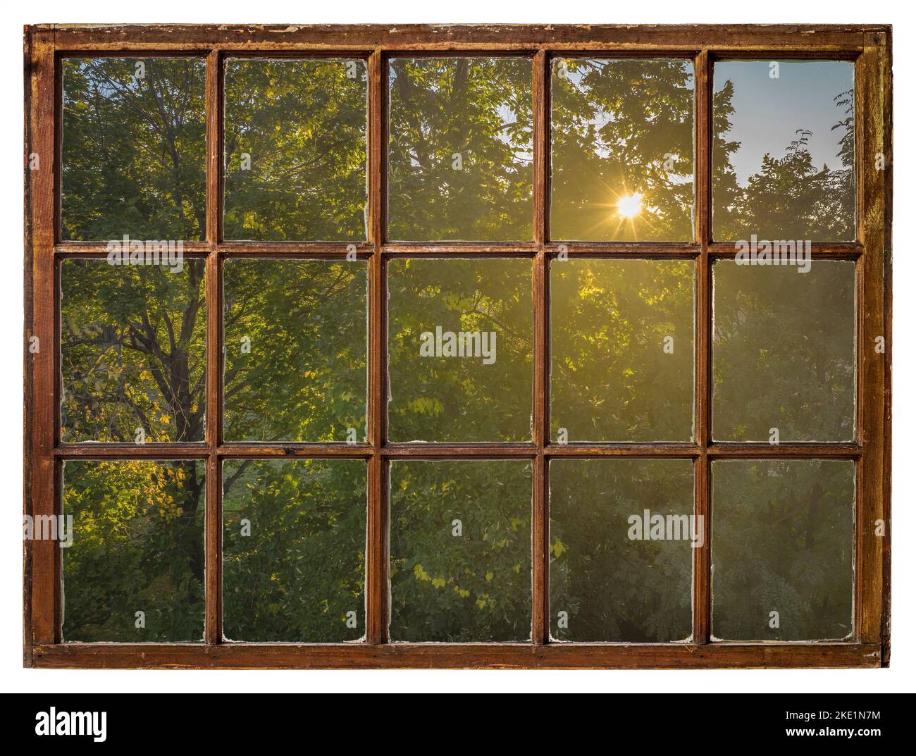 Warme Sonne, die durch das Laub des Baumes scheint, Herbstlandschaft aus einem Vintage-Schiebefenster Stockfoto