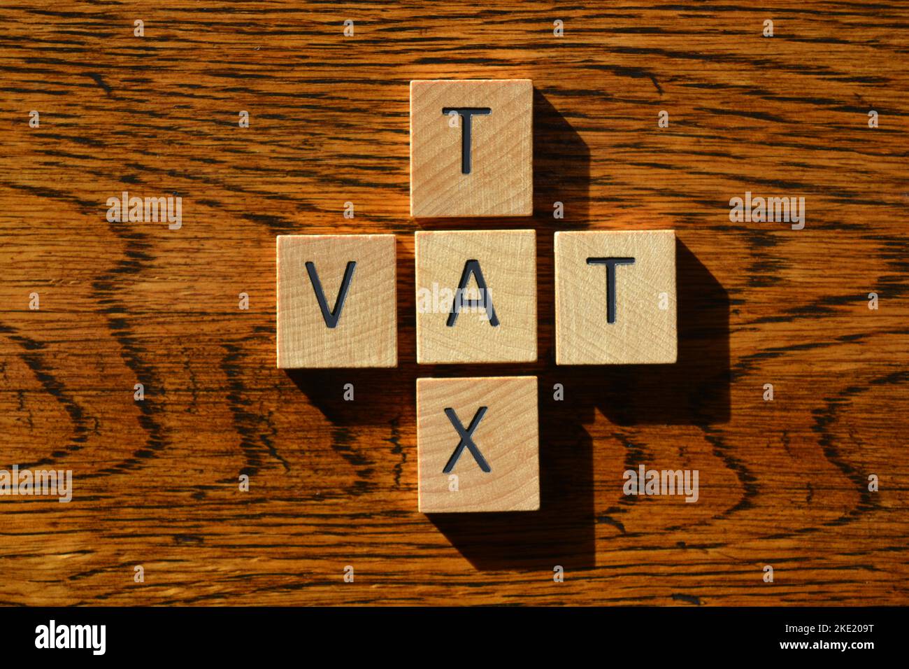 VAT, Akronym für Value Added Tax and Tax, Wort in Holzbuchstaben isoliert auf texturiertem Holzhintergrund Stockfoto