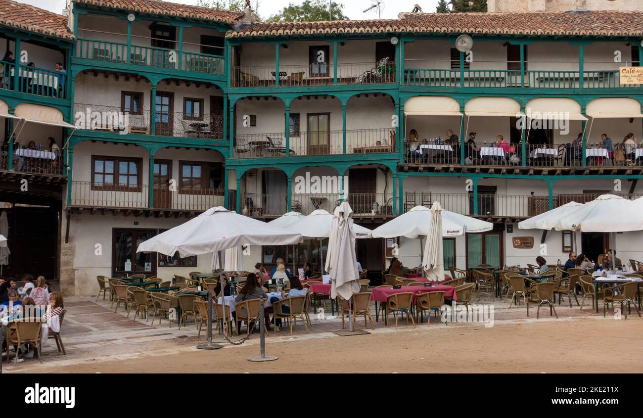 Die Gäste sitzen an Tischen auf Balkonen und am Boden rund um den zentralen platz (der auch als Stierkampfarena fungiert) der spanischen Stadt Chinchon in der Nähe von Madrid, Spai Stockfoto