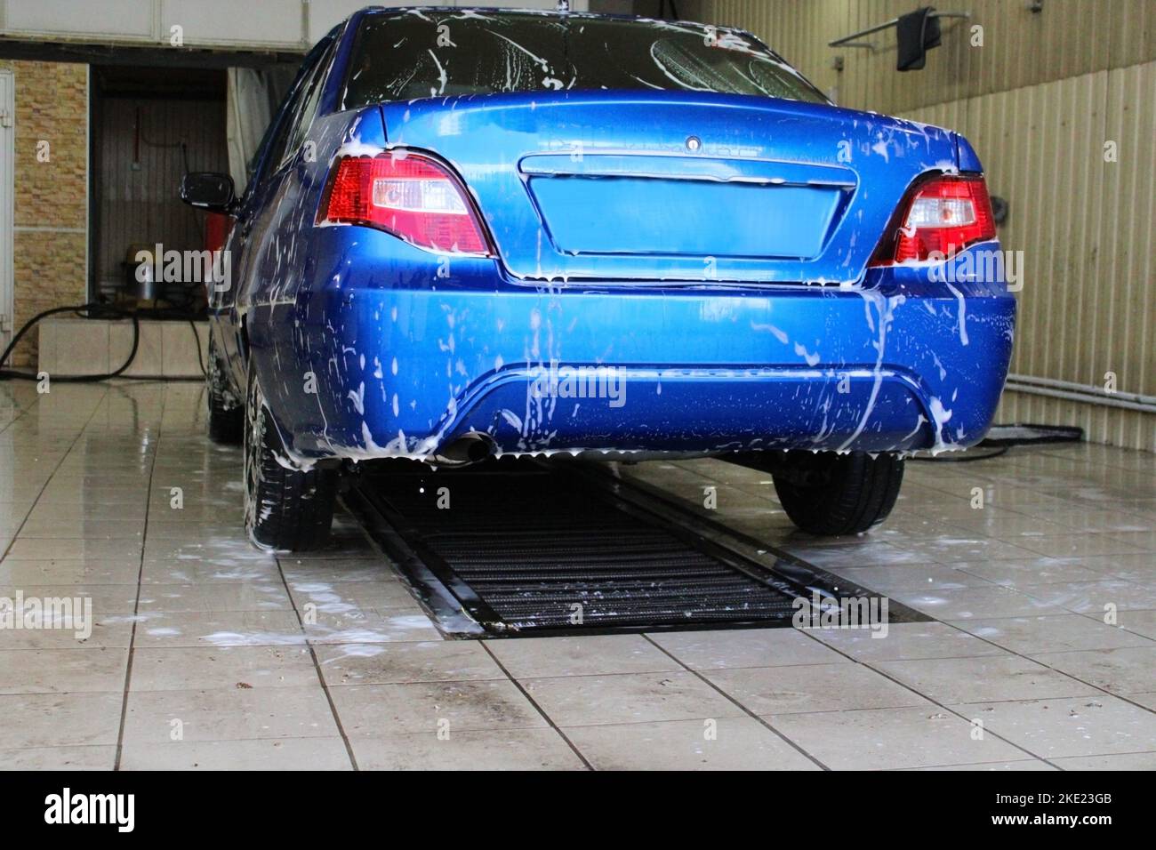 Blaues Auto Nahaufnahme bei der Waschanlage. Konzeption von Ökologie und Umweltverschmutzung. Stockfoto
