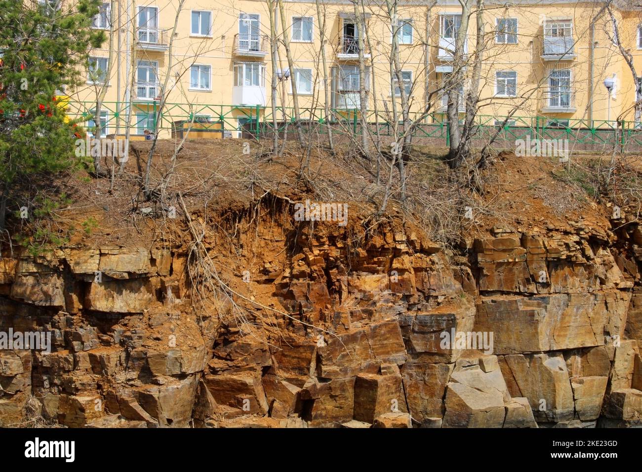 Ein mehrstöckiges Gebäude, das auf einer Klippe eines felsigen Ufers steht. Stockfoto