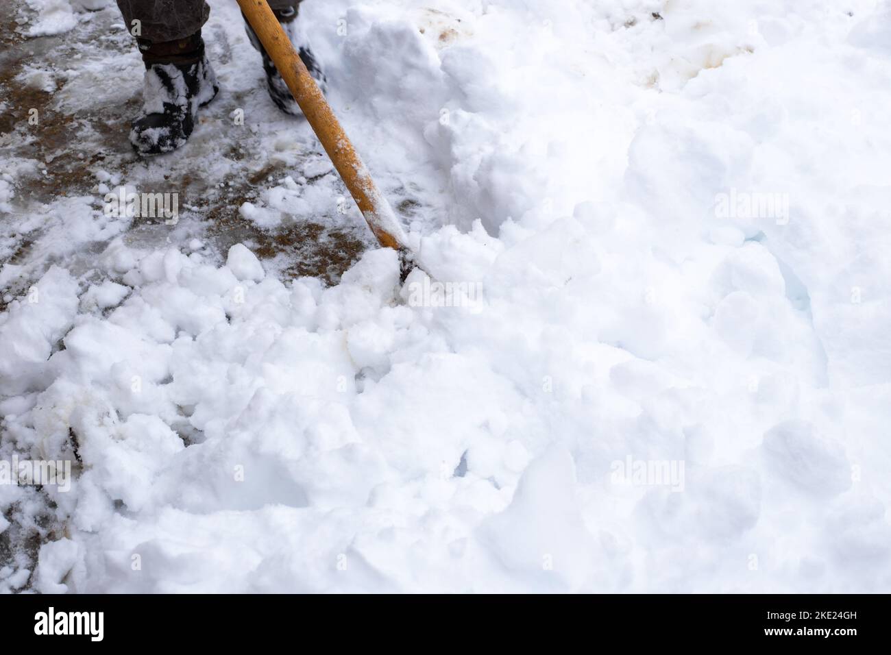 Ein Mann reinigt im Winter Schnee im Hof des Hauses. Ein Mann reinigt den  Schnee mit einer Schaufel Stockfotografie - Alamy