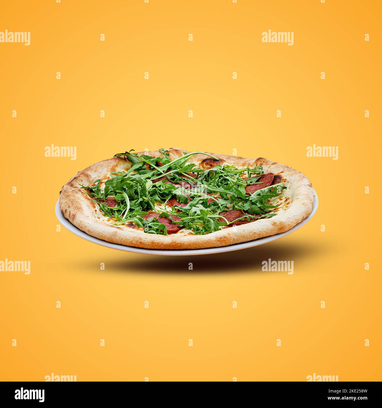 Hausgemachte italienische Pizza auf gelbem Hintergrund. Stockfoto