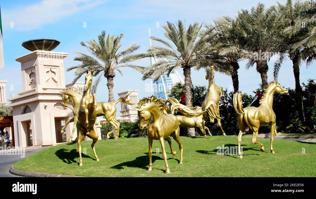 DUBAI, VEREINIGTE ARABISCHE EMIRATE, VAE - 20. NOVEMBER 2017: Luxuriöses 5-Sterne-Hotel JUMEIRAH Al Qasr Madinat, Skulpturen von Goldpferden am Eingang des Hotelkomplexes. Hochwertige Fotos Stockfoto