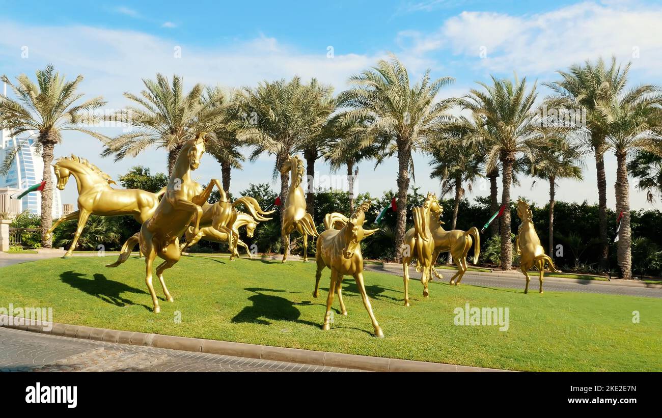 DUBAI, VEREINIGTE ARABISCHE EMIRATE, VAE - 20. NOVEMBER 2017: Luxuriöses 5-Sterne-Hotel JUMEIRAH Al Qasr Madinat, Skulpturen von Goldpferden am Eingang des Hotelkomplexes. Hochwertige Fotos Stockfoto