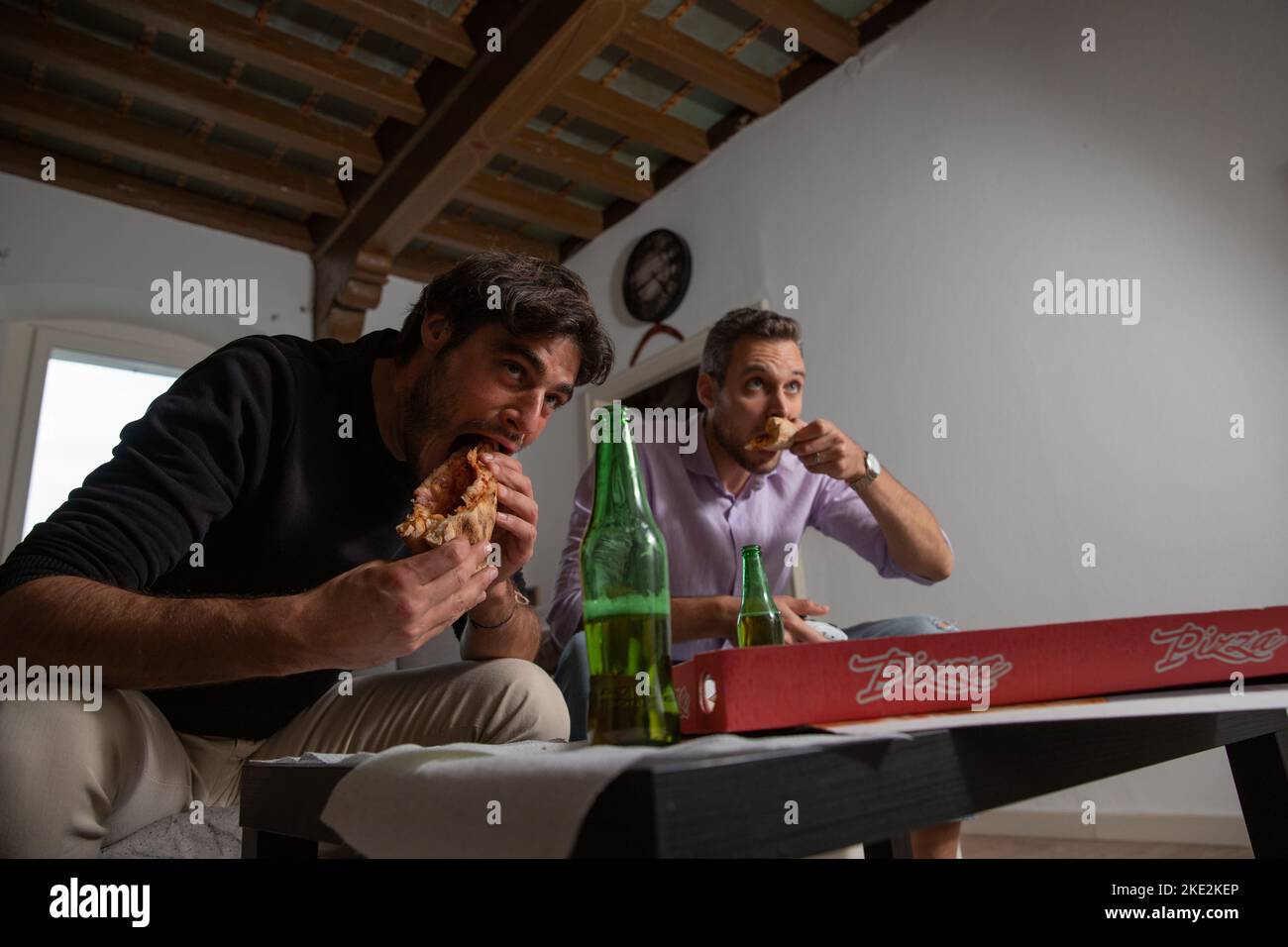 Glückliche Freunde Gamer schnabben sich während eines Videospiel-Spiels, es ist Pizza-Zeit. Stockfoto