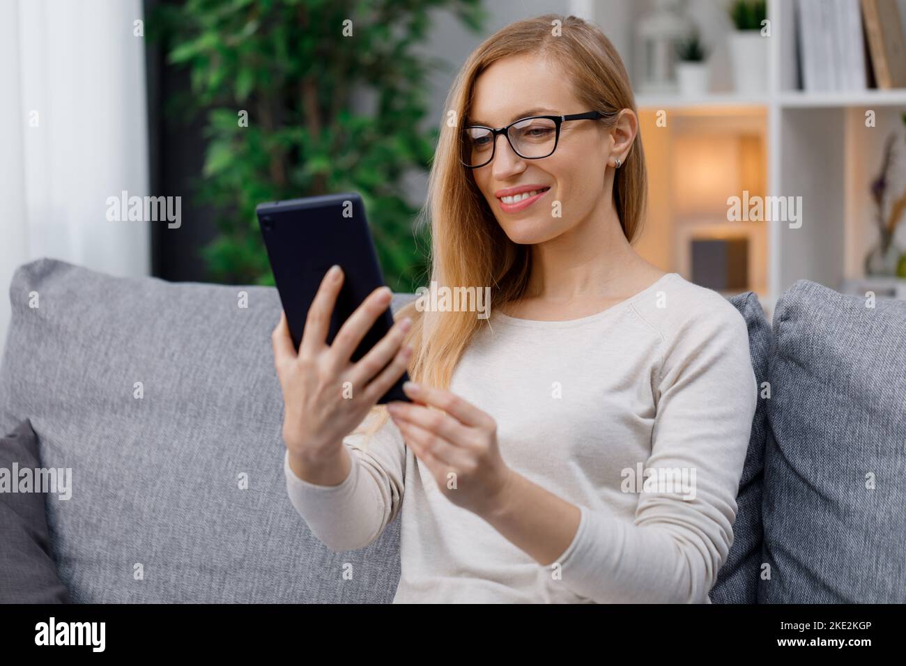 Frau mit Tablet auf sofa Stockfoto