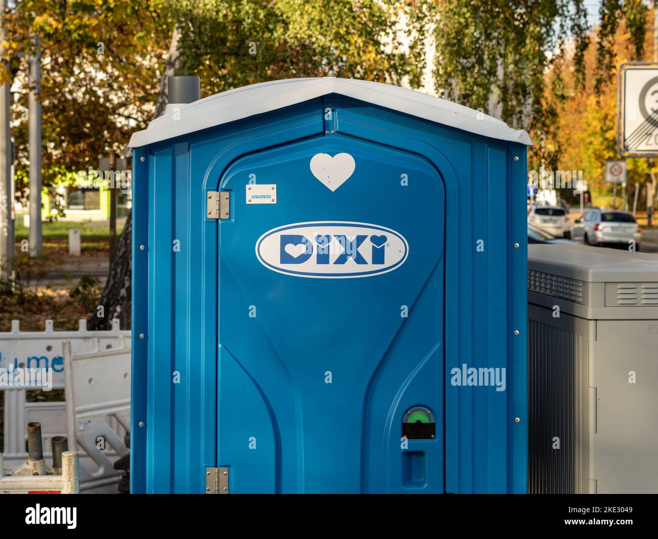 Tragbare Dixi-Toilette auf einer Baustelle. Die blaue Kabine aus Kunststoff ist für Arbeiter. Das Firmenzeichen befindet sich an der verschlossenen Tür. Stockfoto