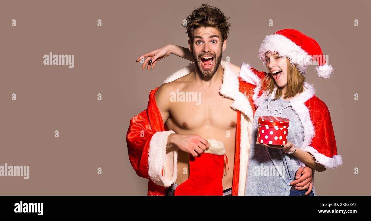 Junges Paar mit weihnachtsgeschenk. Lustige Paar isoliert Hintergrund. Stockfoto