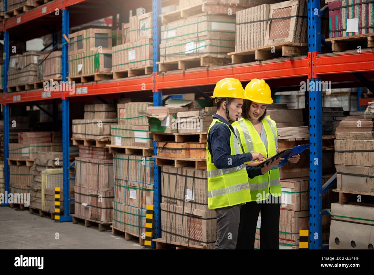 Lagerarbeiter, der Pakete in einem großen Lager überprüft Stockfoto