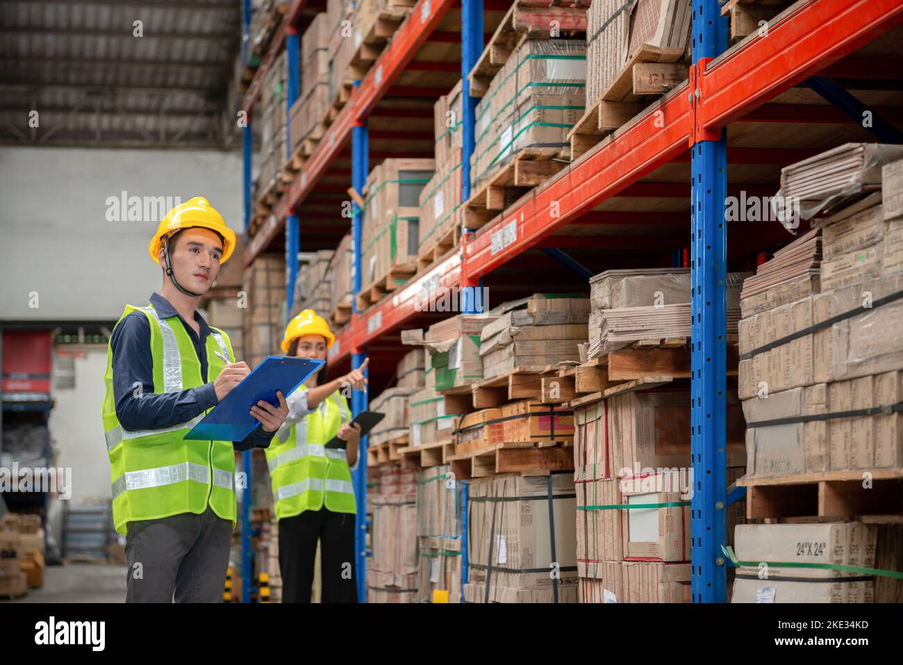 Lagerarbeiter, der Pakete in einem großen Lager überprüft Stockfoto