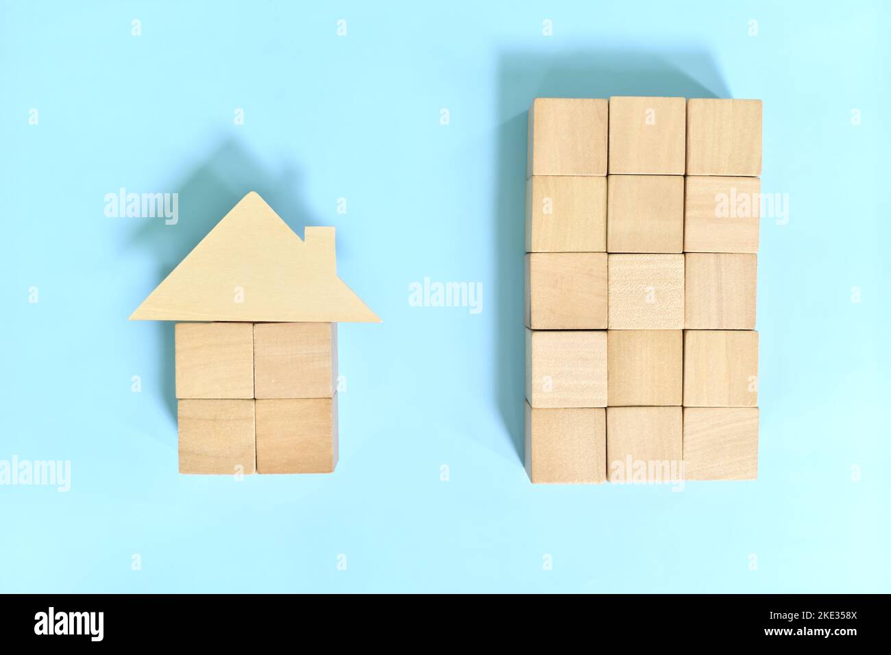Kaufen Eigentumswohnung Einheit gegen Haus und Lot-Konzept. Holzblöcke Gebäude und Haus Modell. Stockfoto
