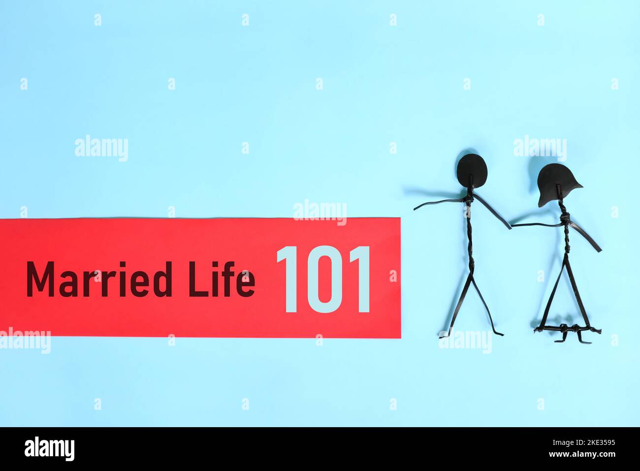 Ehe- oder Eheleben 101 oder Beziehungstipps und Ratschläge für erfolgreiches Konzept. Paar Stick Figur auf blauem Hintergrund. Stockfoto