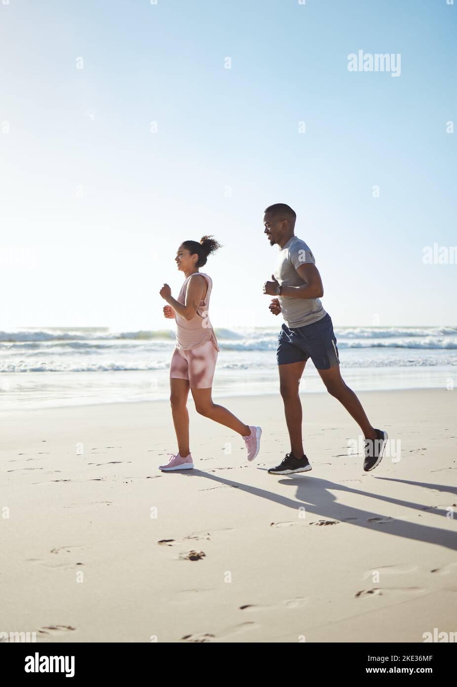 Schwarzes Paar, Strand und Laufen für Fitness, Bewegung und Cardio-Training in Sonnenschein, Sommer und Meersand. Junger Mann, Frau und Läufer Partner auf Stockfoto
