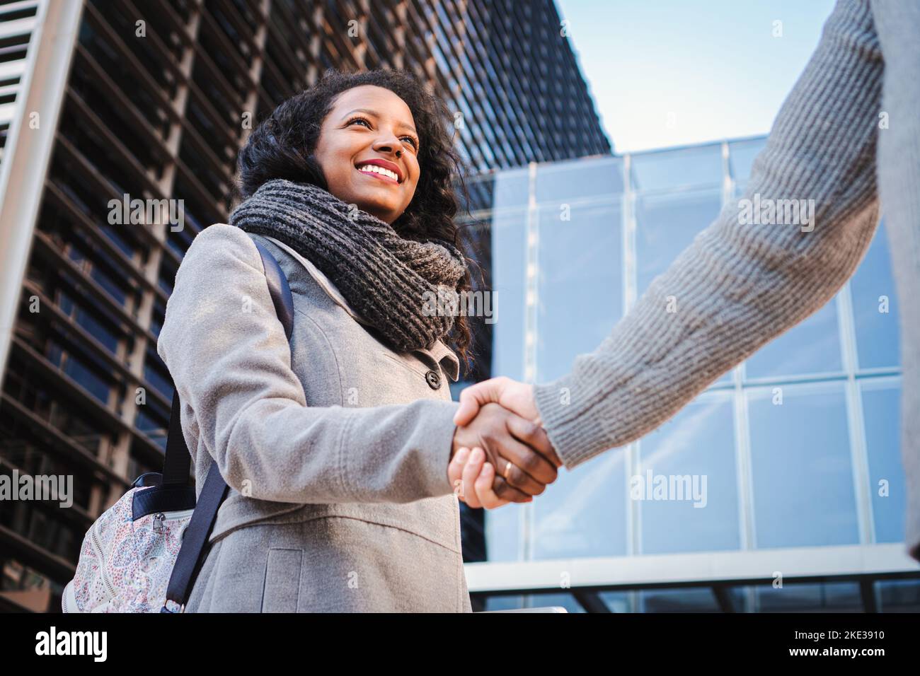 Porträt einer jungen hispanischen Frau, die die Hände schüttelt. Geschäftsleute werden in einem modernen Gebäude handgeschüttelt. Begrüßung des Geschäftskonzepts Stockfoto